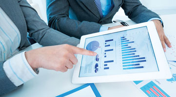 Bilanzen & Co 2 Personen halten Tablet mit Diagrammen