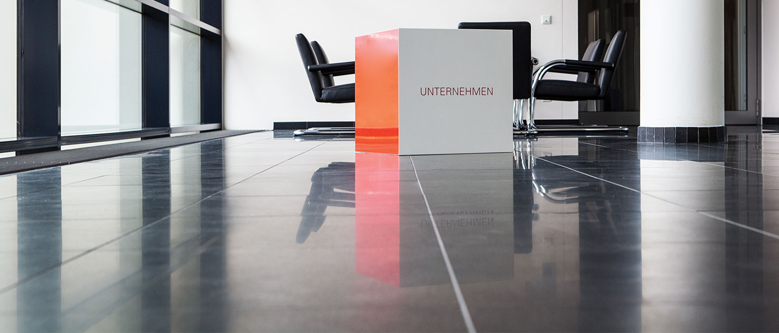 Würfel mit Slogan "Unternehmen" im Gebäudeflur